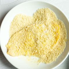 a white bowl filled with yellow food on top of a table