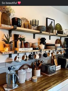 the kitchen counter is covered with pots, pans and utensils on shelves