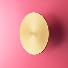 a round object on a pink background