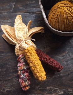 three crocheted objects are sitting on a table next to a ball of yarn