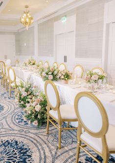 a long table with white and gold chairs is set up for a formal function in the ballroom