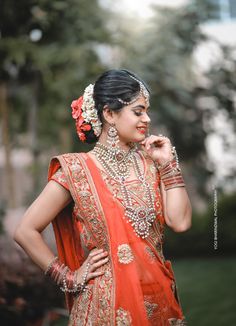 a woman in an orange and gold bridal outfit