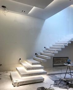 a room that has some stairs lit up in the dark and there is also lighting