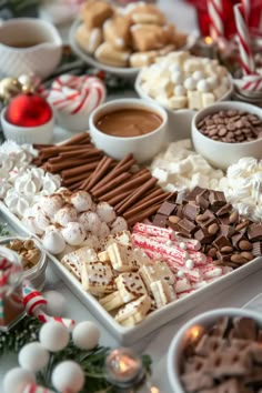 a table topped with lots of different types of candy and candies next to christmas decorations