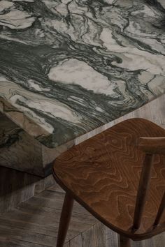 a wooden chair sitting next to a marble table