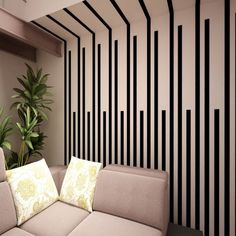 a living room with black and white stripes on the walls, couches and a potted plant