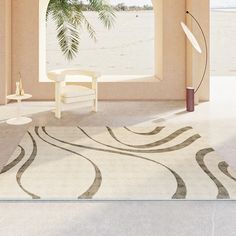 a living room with an area rug, chair and window overlooking the beach in front of it