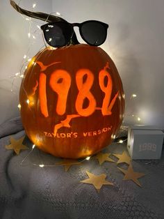 an orange pumpkin with sunglasses on top and the year 1989 carved into it's face