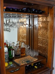 a wooden cabinet with wine glasses and bottles on it