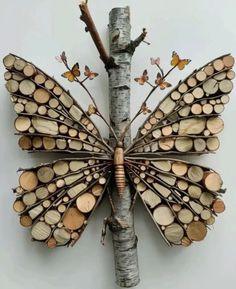 a butterfly made out of wood sitting on top of a tree