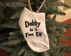 a christmas ornament hanging from a tree with the words dobby is a free elf on it