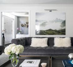 a living room filled with furniture and white flowers