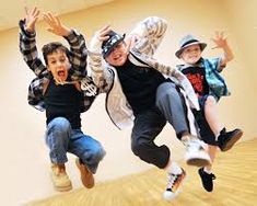 three children jumping in the air on a wooden floor