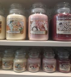 candles are lined up on shelves in a store