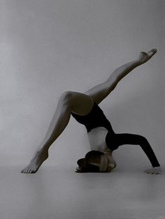 a woman is doing a handstand on the floor