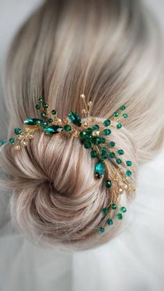 a woman with blonde hair wearing a green and gold leaf headpiece in her hair