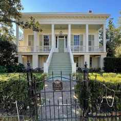 a gated entrance to a large white house