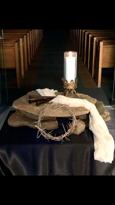 a candle is lit on a table in a church with black cloth and other items