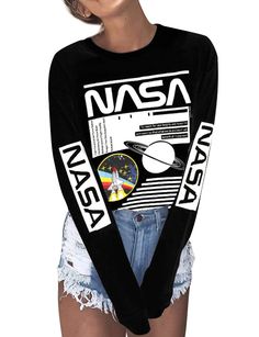 a woman wearing a nasa shirt and ripped shorts