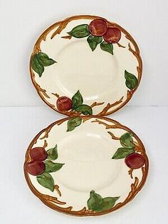 two plates with apples on them are sitting next to each other in front of a white background