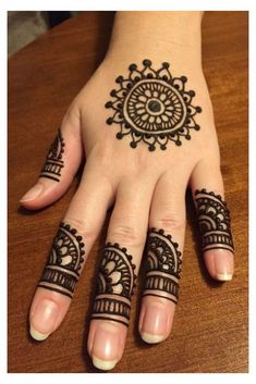 a woman's hand with henna tattoos on it