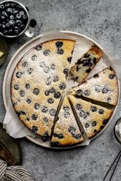 a blueberry cheesecake on a plate with slices cut out and ready to be eaten