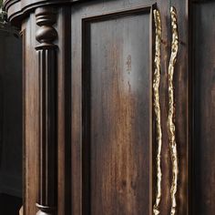 a close up of a wooden door with gold paint on the front and side panels