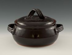 a brown pot with handles and handle sitting on a table