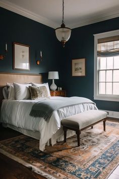 a large bed sitting next to a window in a bedroom on top of a rug