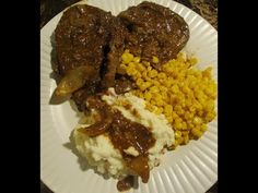 a white plate topped with meat, mashed potatoes and corn on top of it