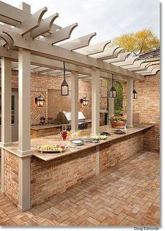 an outdoor kitchen with brick walls and tile flooring