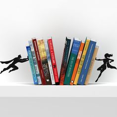 a book shelf filled with books and silhouettes of children running across it, against a white background