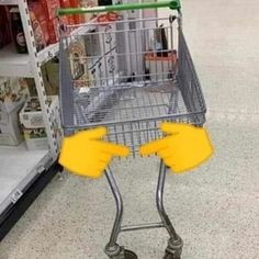 a shopping cart with two yellow gloves on it's legs, in a grocery store aisle