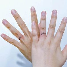 two hands with rings on their fingers and one has a ring in it's middle