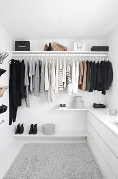 an organized closet with clothes and shoes hanging on the wall, along with other items