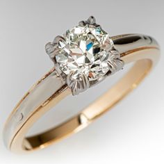 an engagement ring with a diamond in the center and two tone gold bands around it