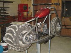 a motorcycle is being worked on in a garage with tools and equipment around the wheel