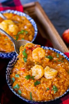 two bowls filled with shrimp and rice on top of a table