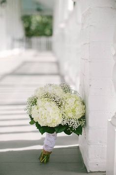 a bouquet of white flowers sitting on the side of a building