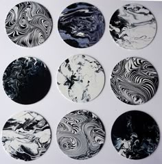 six black and white marble coasters arranged in a circle on top of a table