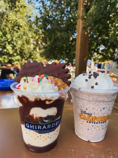 two ice cream sundaes sitting on top of a table