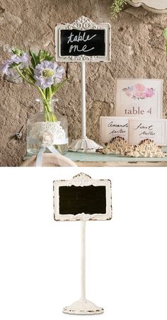 the table is set up for a wedding reception with flowers in vases and chalkboard sign