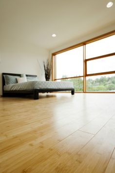 an empty room with wooden floors and large windows