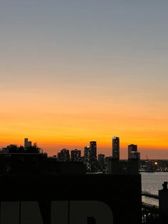 an airplane is flying over the city at sunset