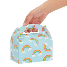 a hand reaching into a small blue box with rainbows and clouds painted on it