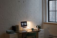 an office desk with a laptop computer sitting on top of it next to a window