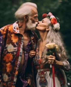 an older man and woman kissing each other with flowers in their hair on the forehead