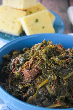 a blue bowl filled with greens and meat