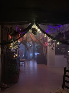 the inside of a house decorated for halloween with lights and spider webs on the ceiling