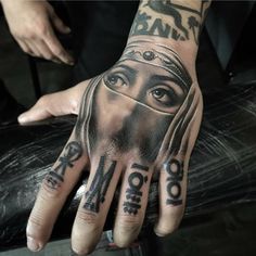 a person with tattoos on their hands and hand is wearing a nun's head